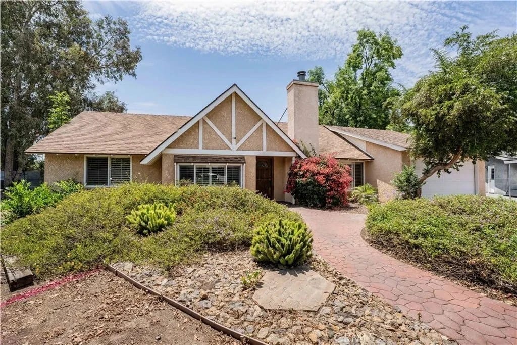 Single-story stucco home with a brick walkway, a California property Quanta financed